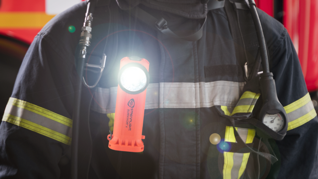 Primer plano de linterna Streamlight Survivor X en el pecho de bombero uniformado